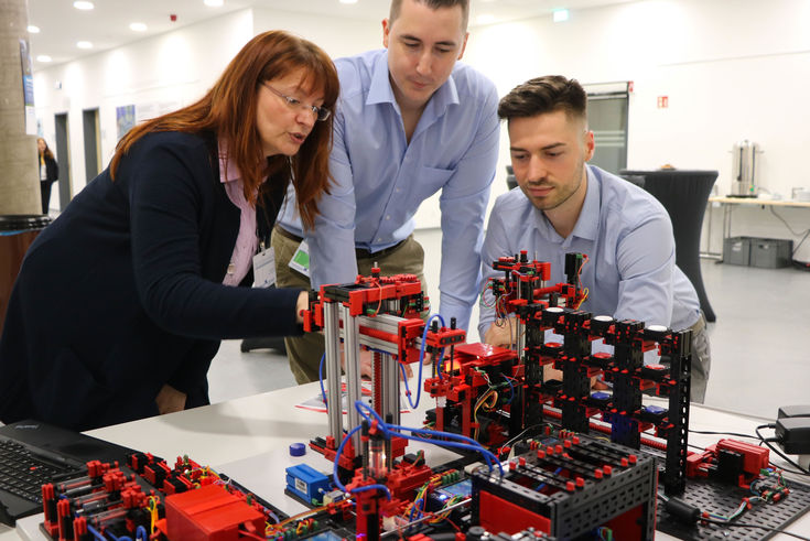 Birgit Lankes, Lehrkraft am Fachbereich Wirtschaftswissenschaften, erklärt Studierenden das Fischertechnik-Modell. 