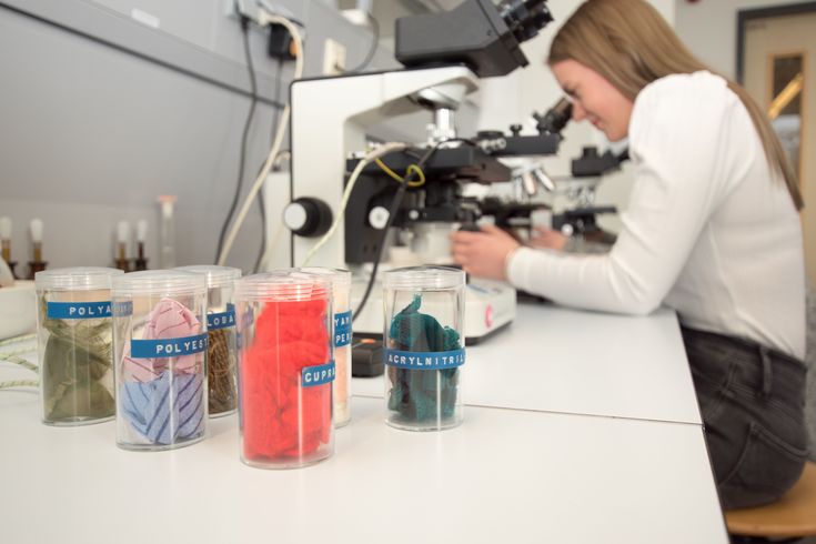Eine Mitarbeiterin im Forschungsinstitut untersucht Polyesterfasern. 