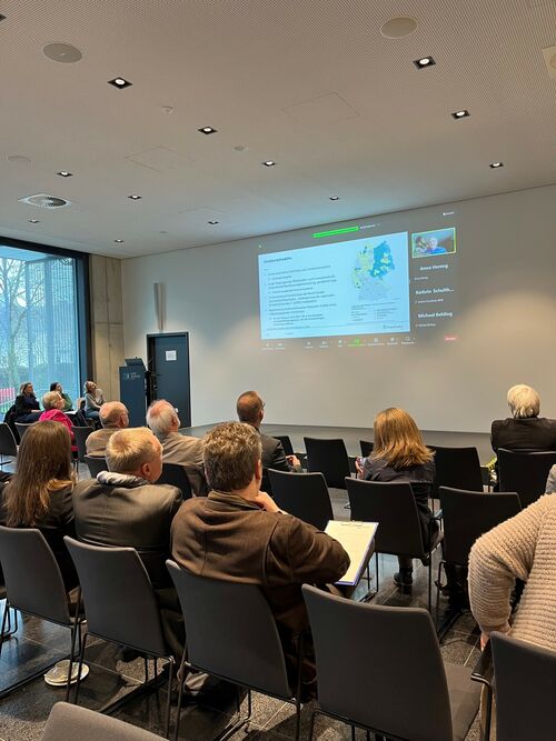 Publikum von hinten mit Blick auf Leinwand