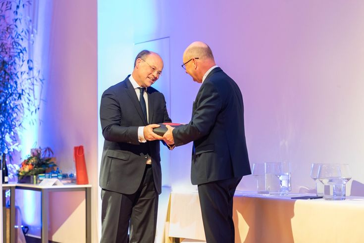 Der Moment der symbolischen Amtsübergabe: Hans-Hennig von Grünberg gibt den elektronischen Hochschul-Schlüssel an Herrn Grünewald weiter.  