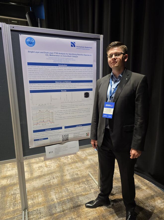 Marcel Sladkov vor seinem Poster.