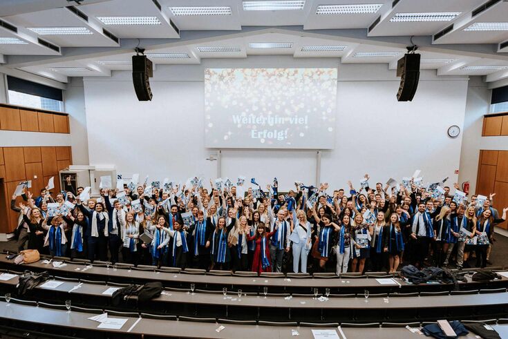 Menschengruppe auf der Bühne des Audimax