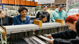 Studierende arbeiten an Webmaschine