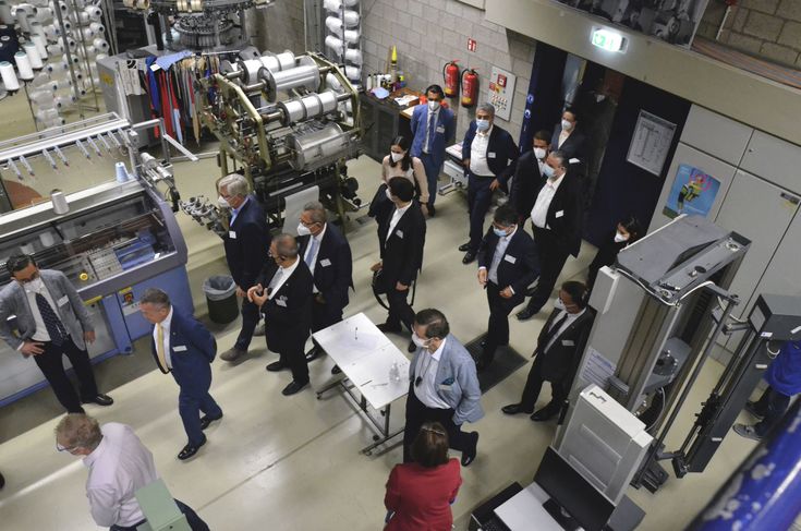 Anlage: Foto: Ein Teil der Wirtschaftsdelegation beim Gang durch die Maschinenhallen des Fachbereichs Textil- und Bekleidungstechnik.  