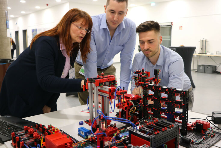 Birgit Lankes, Lehrkraft am Fachbereich Wirtschaftswissenschaften, erklärt Studierenden das Fischertechnik-Modell.