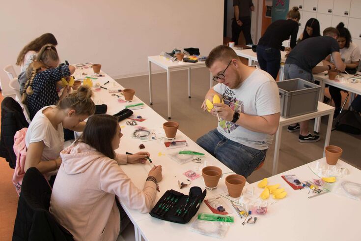 Informatik-Student Noel Bastijans half den Schülerinnen bei der Arbeit.