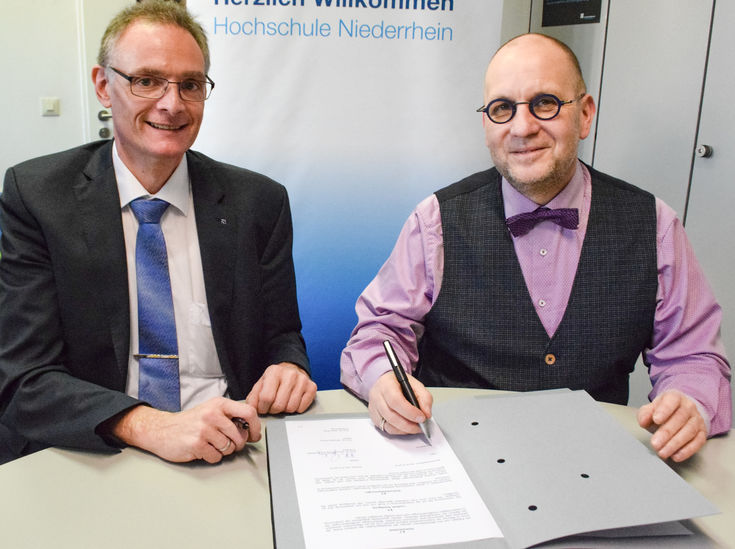 Dekan Prof. Dr. Siegfried Kirsch (links) und Schulleiter Thomas Prell-Holthausen bei der Unterschrift. 