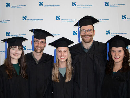 fünf Absolvierende bei einer Abschlussfeier