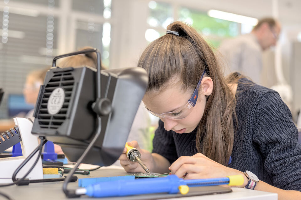 Schülerin lötet im MakerSpace