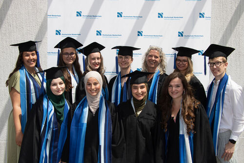 elf Absolvierende bei einer Abschlussfeier