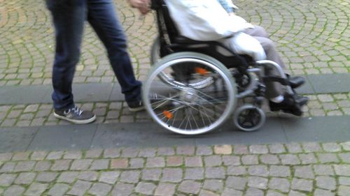 Person im Rollstuhl wird geschoben