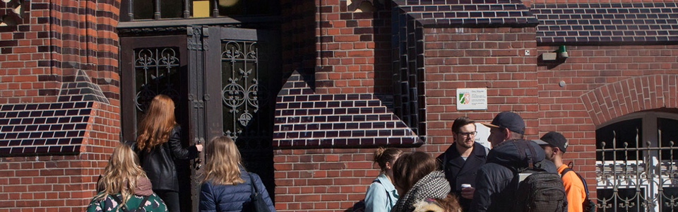 Studierende am Eingang des Hauptgebäudes des Fachbereich Textil und Bekleidungstechnik