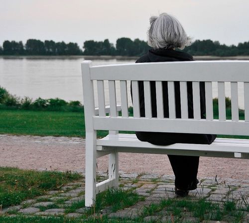 Bild von älterer Frau alleine auf einer Bank