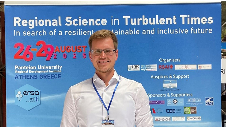 Florian Grebe vor einem Plakat am European Regional Science Association.