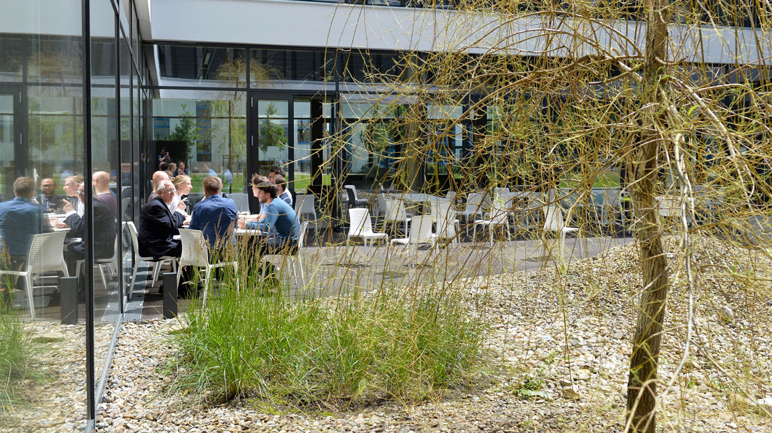 Gruppe von Menschen an Tisch  in Innenhof
